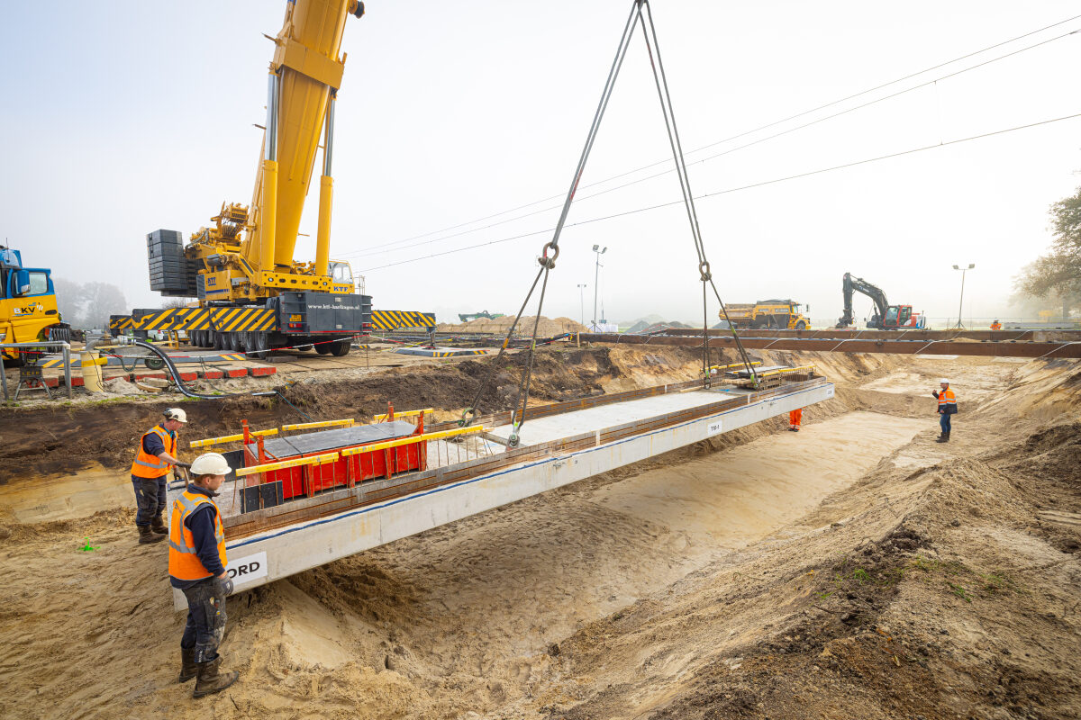 Het inhijsen van het vloerelement van een veetunnel onder het spoor bij Dalfsen