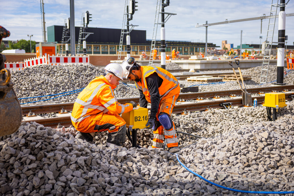 Een Railaansluitpot (RAP) wordt door spoorwerkers geplaatst bij de verbouwing van station Groningen