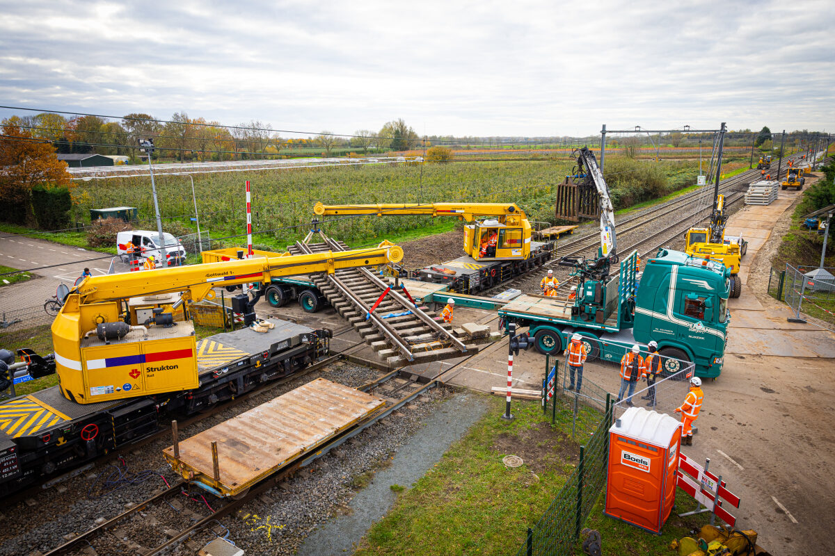 Twee spoorkranen zijn bezig met het verplaatsen van een wisselsectie bij de herstelwerkzaamheden na het treinongeval bij Meteren